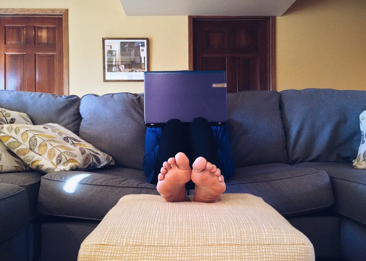 Pessoa trabalhando num escritório iluminado, sentada à mesa com o computador.